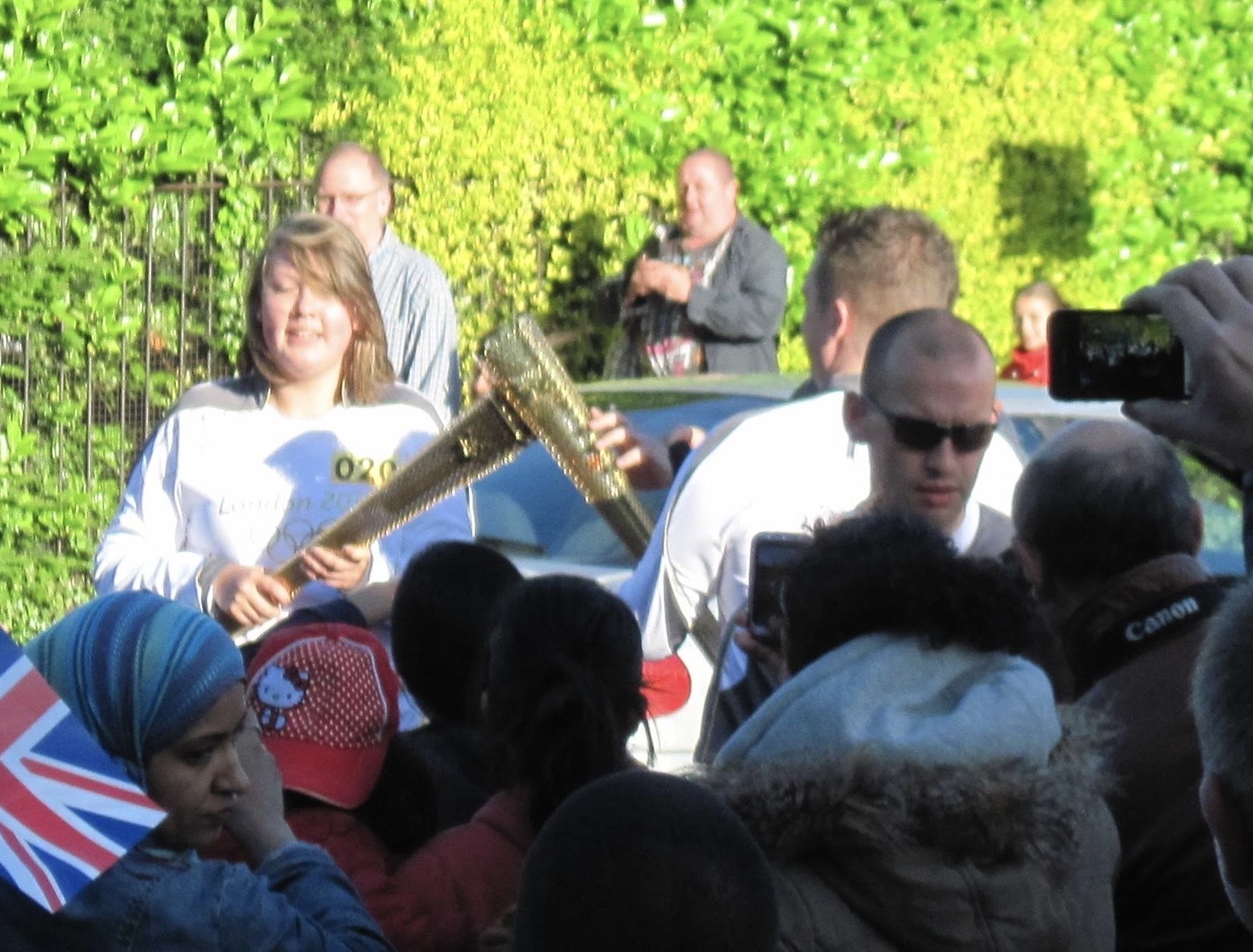 A woman with a gold Olympic torch and a man with a gold Olympic torch